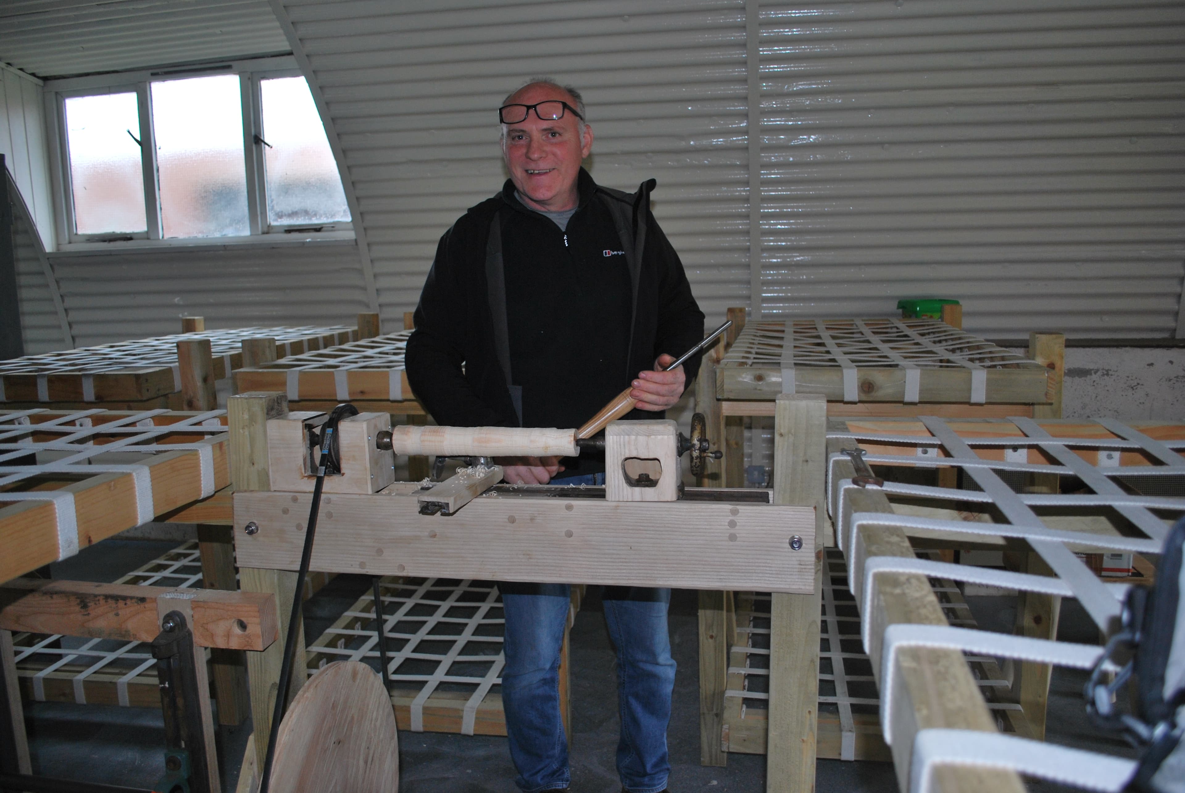 Jim Thomson at work with a handbuilt lathe inside one of the Nissen huts at Cultybraggan Camp, representing the community life the site now sustains